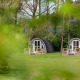 Twee charmante, ronde lodges bij Woodlodge Wilsumer Berge in Duitsland omgeven door groen gebladerte.