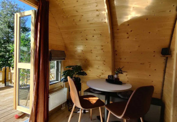 Interno di un lodge in legno al Woodlodge, Wilsumer Berge, Germania, con tavolo, sedie e finestra aperta.