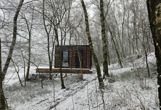 Cabaña Nokken NKN-18 en Wilsumer Berge, Alemania, rodeada de árboles nevados en un bosque invernal.