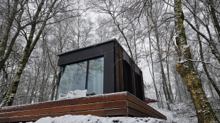 Cabine Nokken NKN-18 à Wilsumer Berge, Allemagne, entourée d'arbres enneigés et d'une architecture moderne.