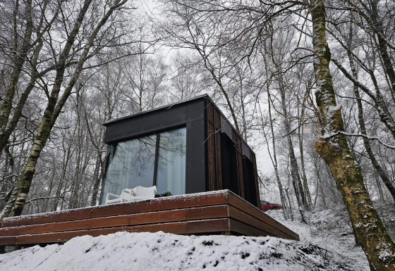 Nokken NKN-18 Cabin ved Wilsumer Berge i Tyskland, omgivet af sneklædte træer og moderne arkitektur.