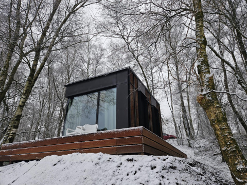 Cabine Nokken NKN-18 à Wilsumer Berge, Allemagne, entourée d'arbres enneigés et d'une architecture moderne.