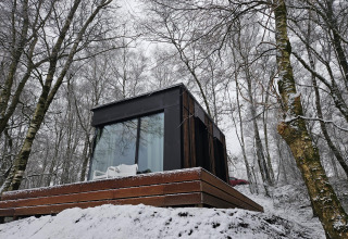 Nokken NKN-18 Cabin ved Wilsumer Berge i Tyskland, omgivet af sneklædte træer og moderne arkitektur.