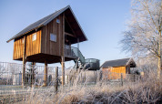 Baumhaus im Holiday Park Mölke, Niederlande, an einem frostigen Morgen mit blauem Himmel.