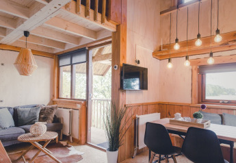 Licht en gezellig interieur van een boomhut bij Holiday Park Mölke, Nederland, met moderne houten inrichting.