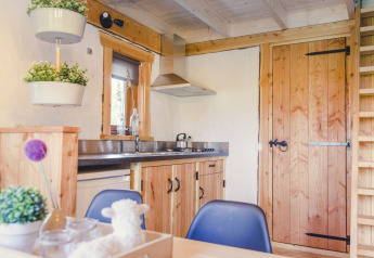 Gemütliche Küche im Baumhaus im Holiday Park Mölke in den Niederlanden mit Holzmöbeln und Pflanzen.