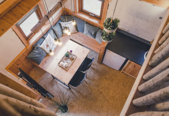 Bovenaanzicht van een gezellige boomhut bij Holiday Park Mölke met eethoek en compacte keuken.