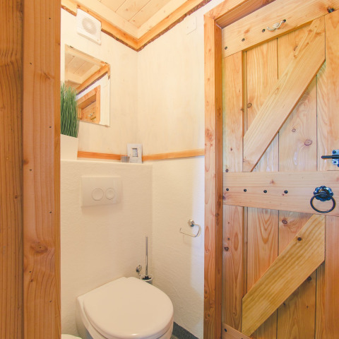 Salle de bains en bois clair avec toilettes modernes dans une cabane dans les arbres à Holiday Park Mölke, Pays-Bas.