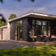 Modern river lodge at Holiday Park Mölke in the Netherlands, featuring a spacious patio and lounge chairs.