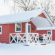 Chalets scandinaves rouges couverts de neige à Holiday Park Mölke, aux Pays-Bas, en hiver.
