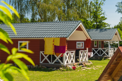 Cabañas escandinavas rojas con terrazas blancas en Holiday Park Mölke, Países Bajos, día soleado.