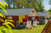 Skandinavische Lodges mit weißen Veranden im Holiday Park Mölke, Niederlande, sonniger Sommertag.