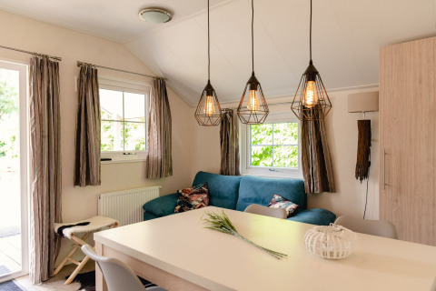 Lyst og hyggeligt opholdsrum i skandinavisk lodge ved Holiday Park Mölke, Nederlandene, med moderne indretning.