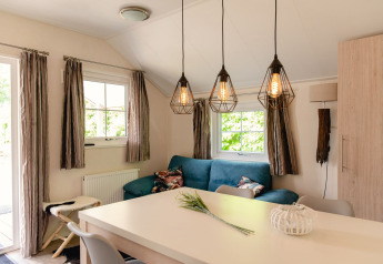 Lyst og hyggeligt opholdsrum i skandinavisk lodge ved Holiday Park Mölke, Nederlandene, med moderne indretning.
