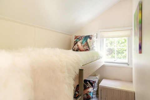 Helles Zimmer mit Hochbett und großem Fenster in einer skandinavischen Lodge im Holiday Park Mölke, Niederlande.