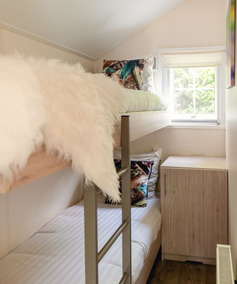 Lichte kamer met stapelbedden en moderne inrichting in een Scandinavische lodge bij Holiday Park Mölke, Nederland.