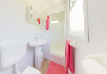 Lichte, moderne badkamer in een Scandinavian lodge bij Holiday Park Mölke, Nederland, met roze accenten.