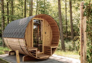 Panoramasauna aus Holz im Grünen bei der Nature Lodge, Wilsumer Berge, Deutschland, im Sonnenschein.
