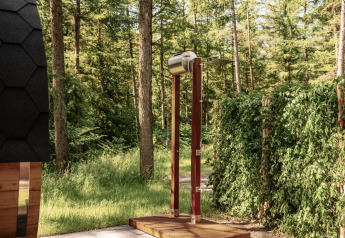 Doccia esterna presso un lodge circondato dalla natura e dagli alberi, a Wilsumer Berge in Germania.