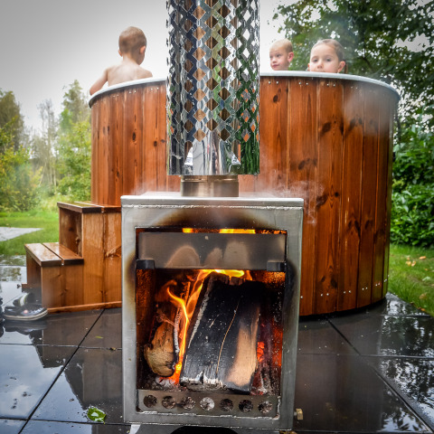 Kinder entspannen im Hot Tub neben einem Holzofen bei Holiday Park Mölke, Niederlande.