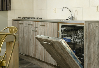 Moderne keuken in de Baby & children bungalow op Holiday Park Mölke, Nederland, met open vaatwasser.