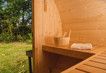 Wooden sauna bench at Luxury Lodge, Vakantiepark Hölte, Netherlands, with bucket and towel inside.
