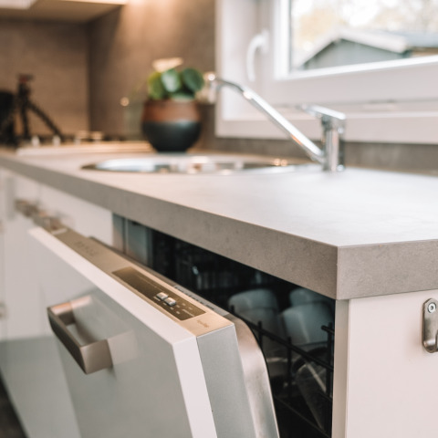 Modern sink and dishwasher in a tiny house kitchen at River Cabin, Holiday Park Mölke, Netherlands.