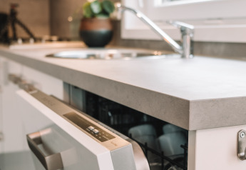 Modern sink and dishwasher in a tiny house kitchen at River Cabin, Holiday Park Mölke, Netherlands.