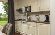 Compact kitchen inside a tiny house at Holiday Park Mölke, Netherlands, featuring all essentials.