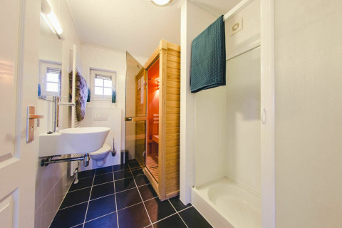 Salle de bain moderne avec douche, sauna et toilettes dans un tiny house à Holiday Park Mölke, Pays-Bas.