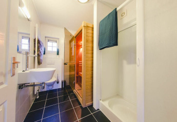 Moderne badkamer met douche, sauna en toilet in een tiny house op Holiday Park Mölke, Nederland.