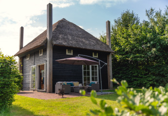 Gezellige groepsaccommodatie Reggehooiberg met rieten dak, terras en ruime tuin midden in het groen.