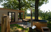 Outdoor area of the Nature lodge with sauna and hot tub at Holiday Park Mölke, surrounded by Dutch nature.