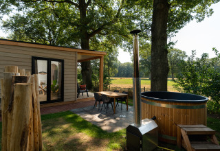Zona exterior de la Nature lodge con sauna y jacuzzi en Holiday Park Mölke, rodeada de naturaleza holandesa.