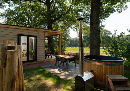 Buitenruimte van de Nature lodge met sauna en hot tub bij Holiday Park Mölke, omgeven door Nederlandse natuur.