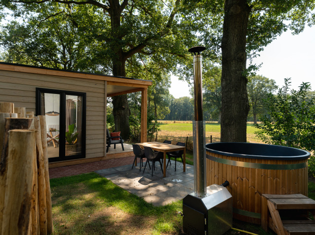 Buitenruimte van de Nature lodge met sauna en hot tub bij Holiday Park Mölke, omgeven door Nederlandse natuur.