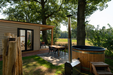 Außenbereich der Nature Lodge mit Sauna und Whirlpool im Holiday Park Mölke, umgeben von Natur in Holland.