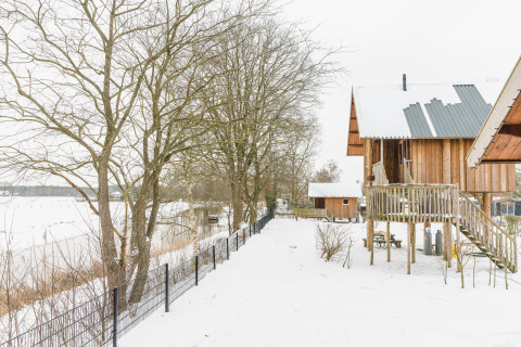 Cabañas de madera en paisaje nevado en Holiday Park Mölke, Regge Cottage, Países Bajos, invierno.