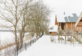 Cabañas de madera en paisaje nevado en Holiday Park Mölke, Regge Cottage, Países Bajos, invierno.