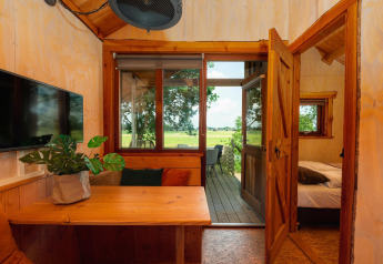 Vista interna del Regge Cottage con arredi in legno e panorami rurali nei Paesi Bassi.