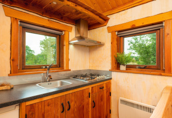 Petite cuisine chaleureuse du Regge Cottage, bois, gazinière, vue verdoyante à Holiday Park Mölke.