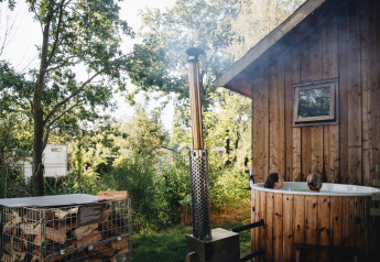 Bubbelbad buiten naast houten huisje bij Regge Cottage op Holiday Park Mölke, Nederland.