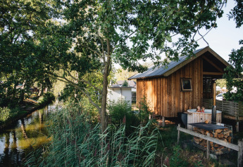 Gemütliches Holzhaus mit Außen-Whirlpool am Fluss inmitten der Natur im Holiday Park Mölke, Niederlande.