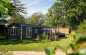 Photo of Bungalette basic plus hot tub at Holiday Park Mölke, Netherlands, with garden and trees around.