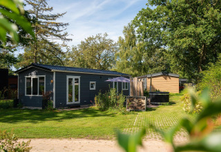 Foto de Bungalette basic con jacuzzi en Holiday Park Mölke, Países Bajos, rodeado de césped y naturaleza.