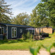Foto de Bungalette basic con jacuzzi en Holiday Park Mölke, Países Bajos, rodeado de césped y naturaleza.