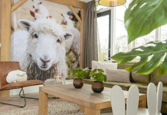 Woonruimte in de Baby & kinderbungalow bij Holiday Park Mölke, Nederland, met grote foto van een schaap.