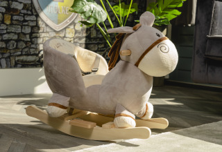 Juguete de caballo mecedora suave en un bungalow infantil en Holiday Park Mölke, Países Bajos, al sol.