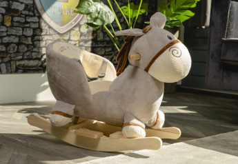 Soft rocking horse toy inside a child-friendly lodge at Holiday Park Mölke, Netherlands, with sunlight.