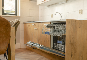 Lavastoviglie integrata in cucina moderna con finitura in legno al Baby & children bungalow, Holiday Park Mölke, Paesi Bassi.